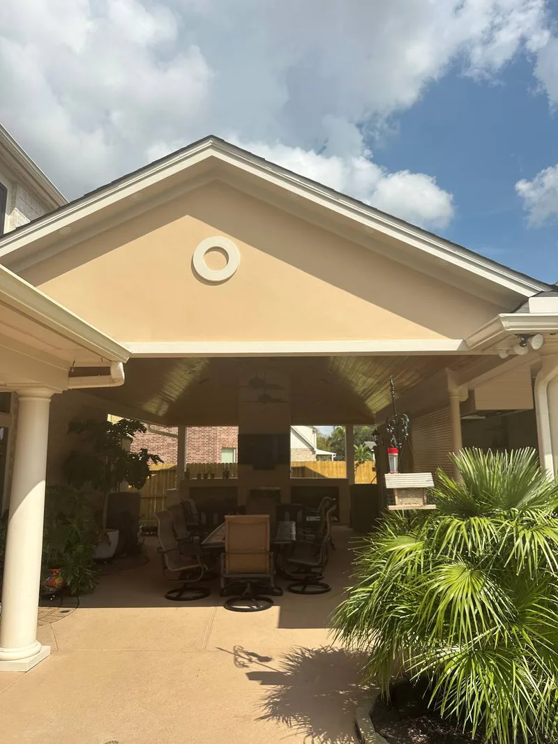 covered patio with white columns ceiling fan and paver floor in Houston TX