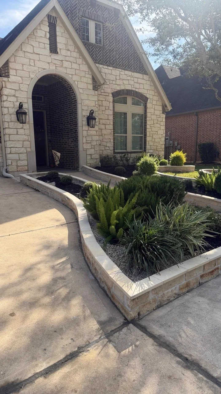 Curved natural stone planter and retaining wall in front yard Houston TX