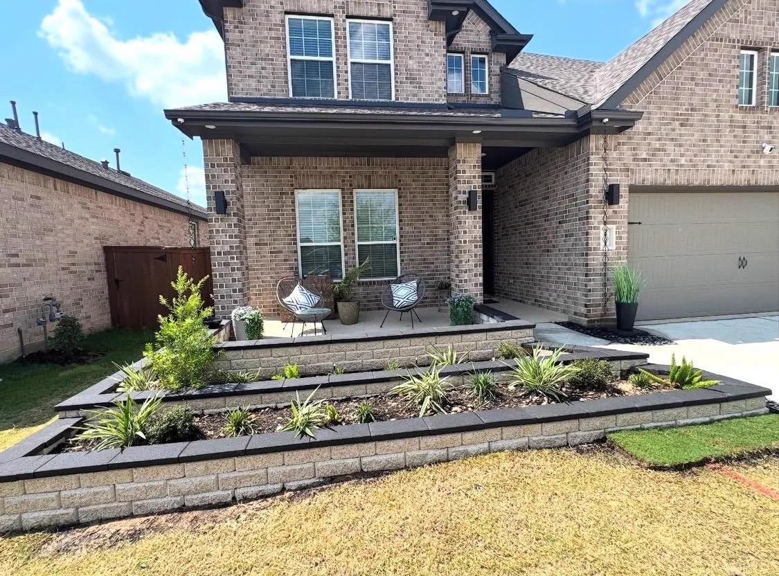Tiered stone planters and porch steps with lush landscaping in Houston TX