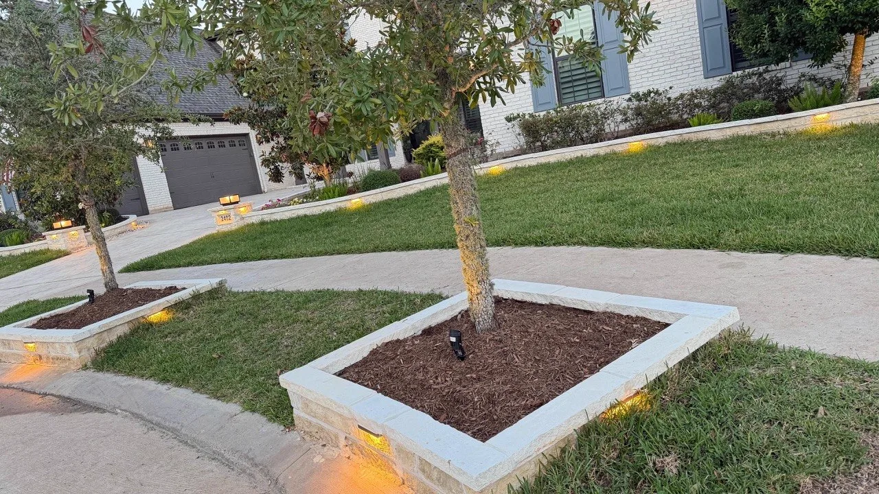Stone tree rings and retaining wall with LED landscape lighting in Houston TX