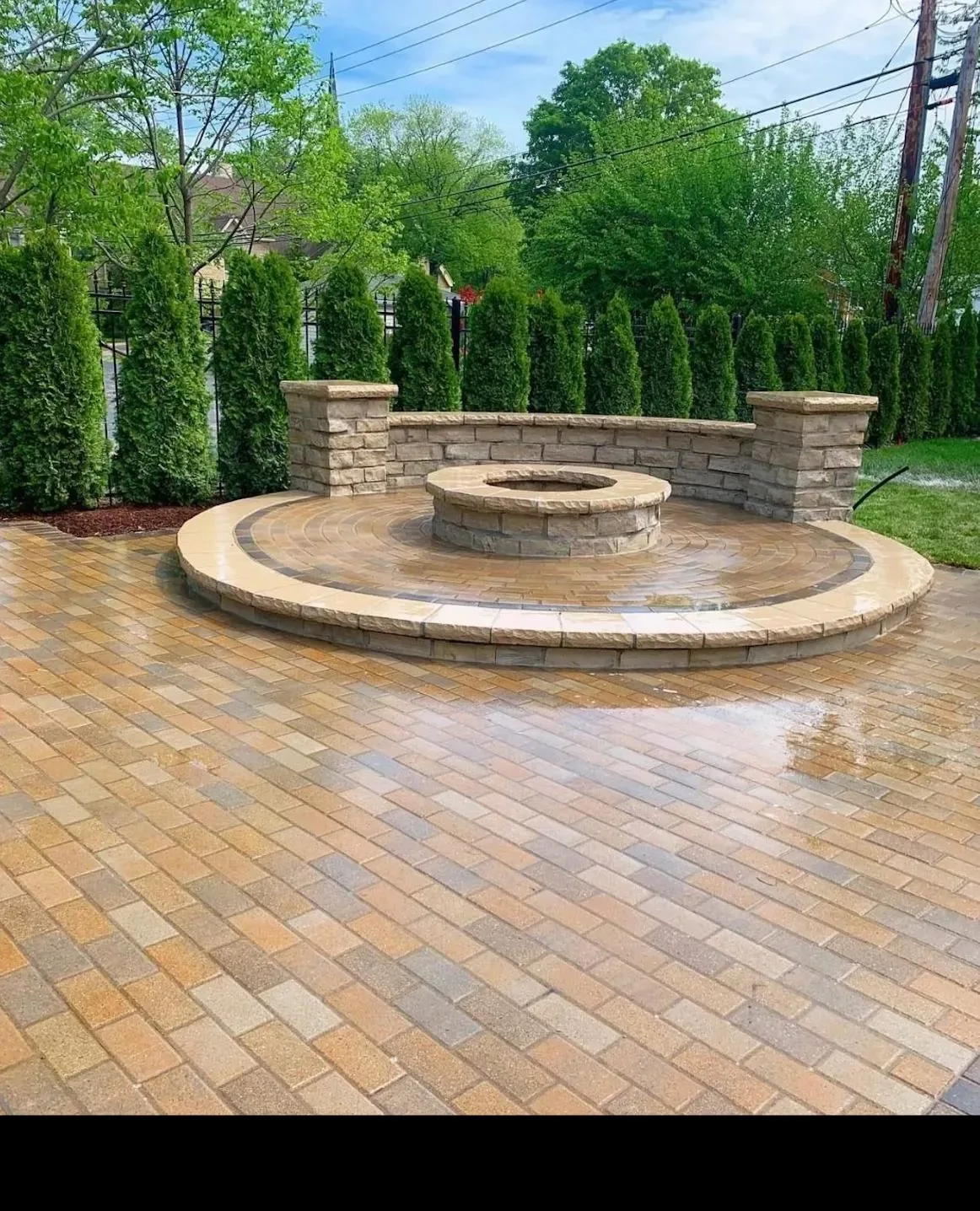 Modern circular fire pit with stone surround and outdoor seating in Houston TX