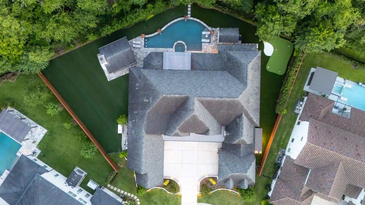 aerial view of luxury home with pool artificial turf and hardscape in Houston TX