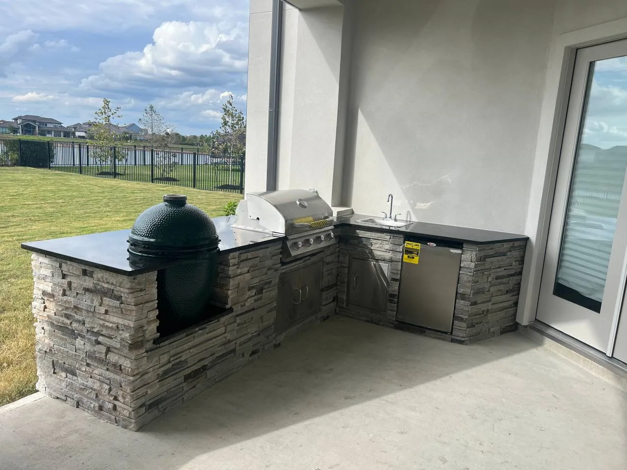 Custom outdoor kitchen with stone counters and built-in grill in Houston TX