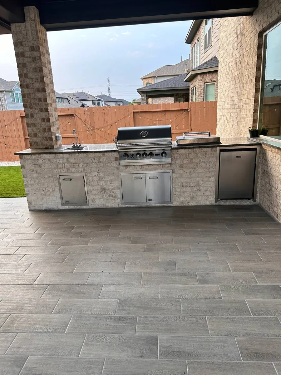Custom outdoor kitchen with stone island and seating bar in Houston TX
