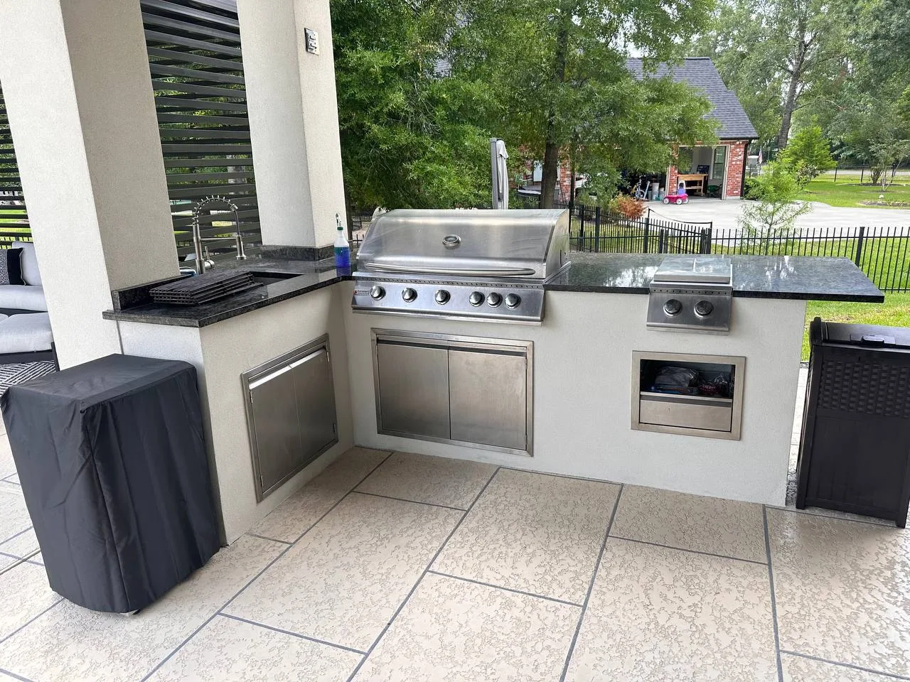 Luxury outdoor kitchen with granite counters and refrigerator in Houston TX