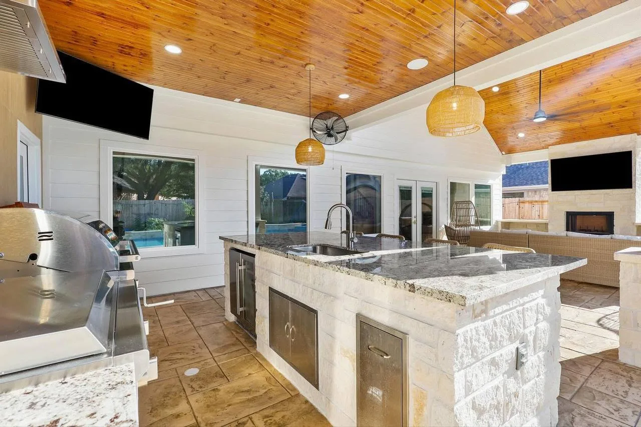 Custom outdoor kitchen with stone island and built-in grill in Houston TX