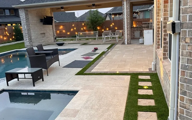 custom outdoor living space with pool covered patio travertine and artificial turf in Houston TX