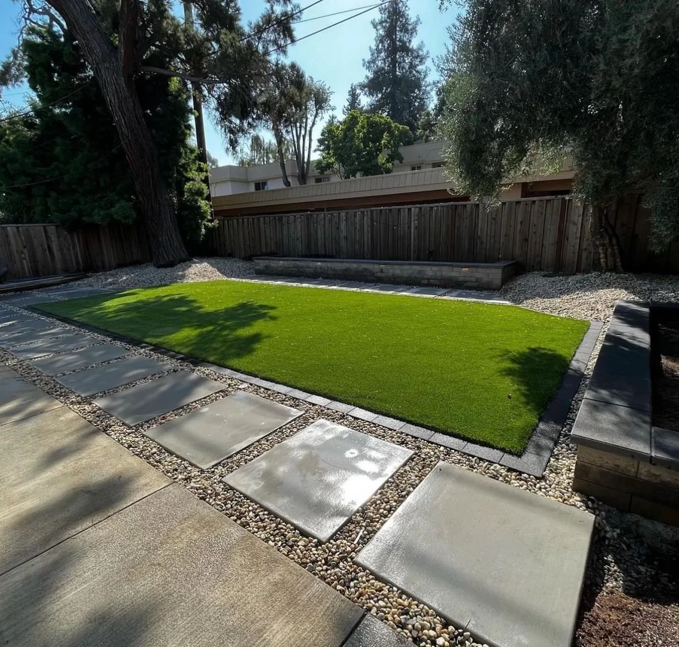 side-by-side comparison of artificial turf and natural grass in a Texas backyard