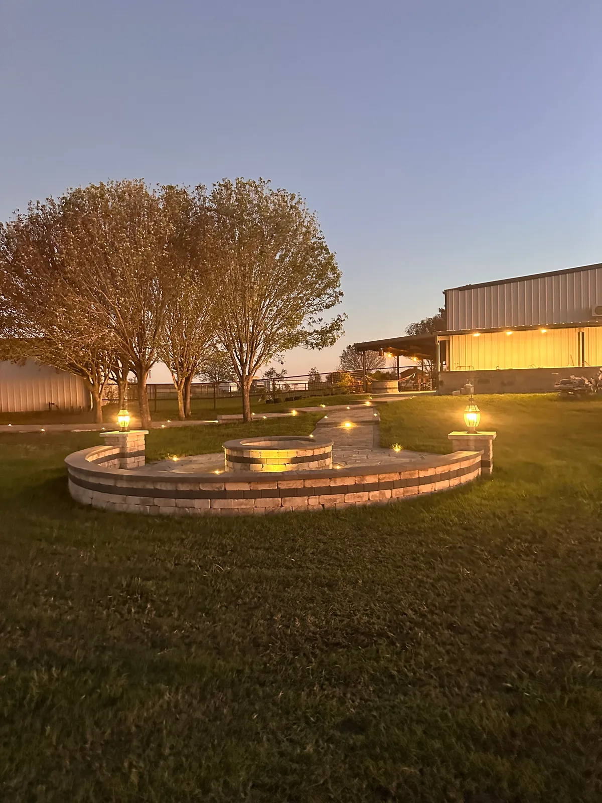 Custom rectangular fire feature with stone surround and outdoor seating in Houston TX