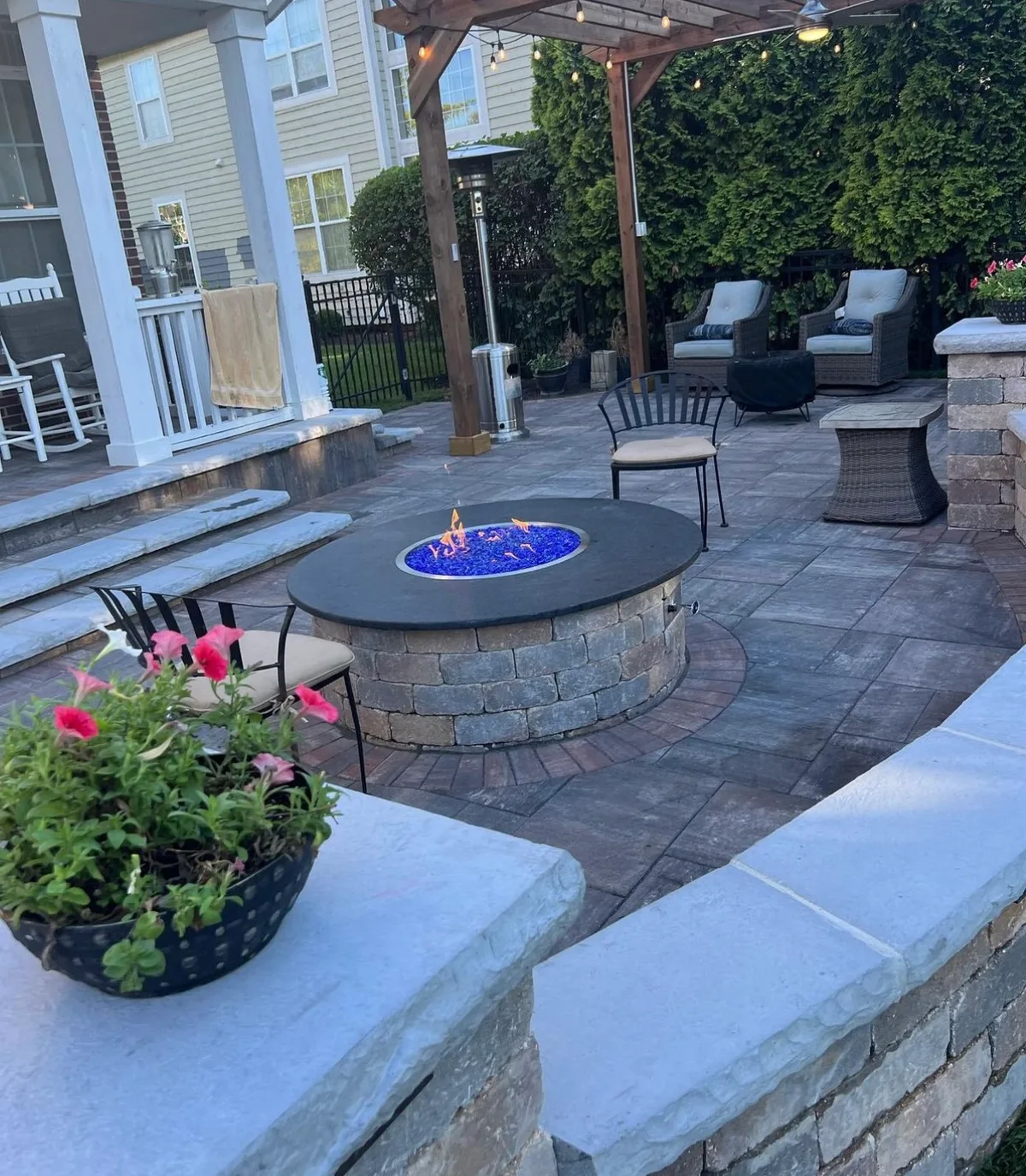 Custom fire pit with stone surround and evening lighting in Houston TX
