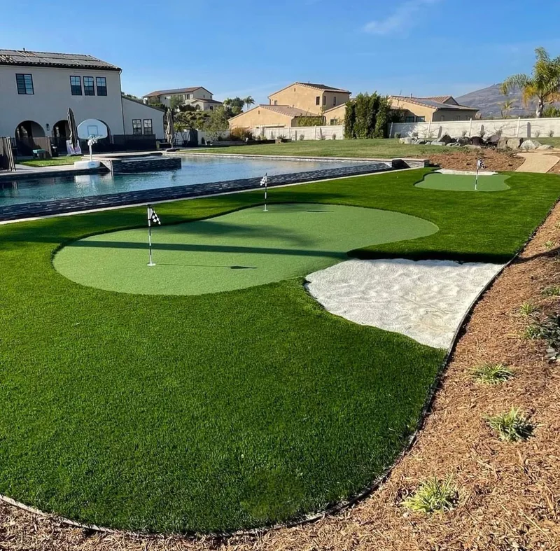 Large estate putting green with sand bunker and swimming pool in Katy TX