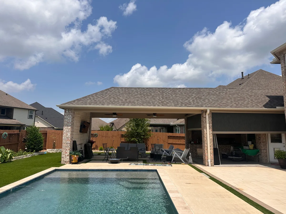 Freestanding patio cover with brick columns pool travertine and artificial turf in Houston TX