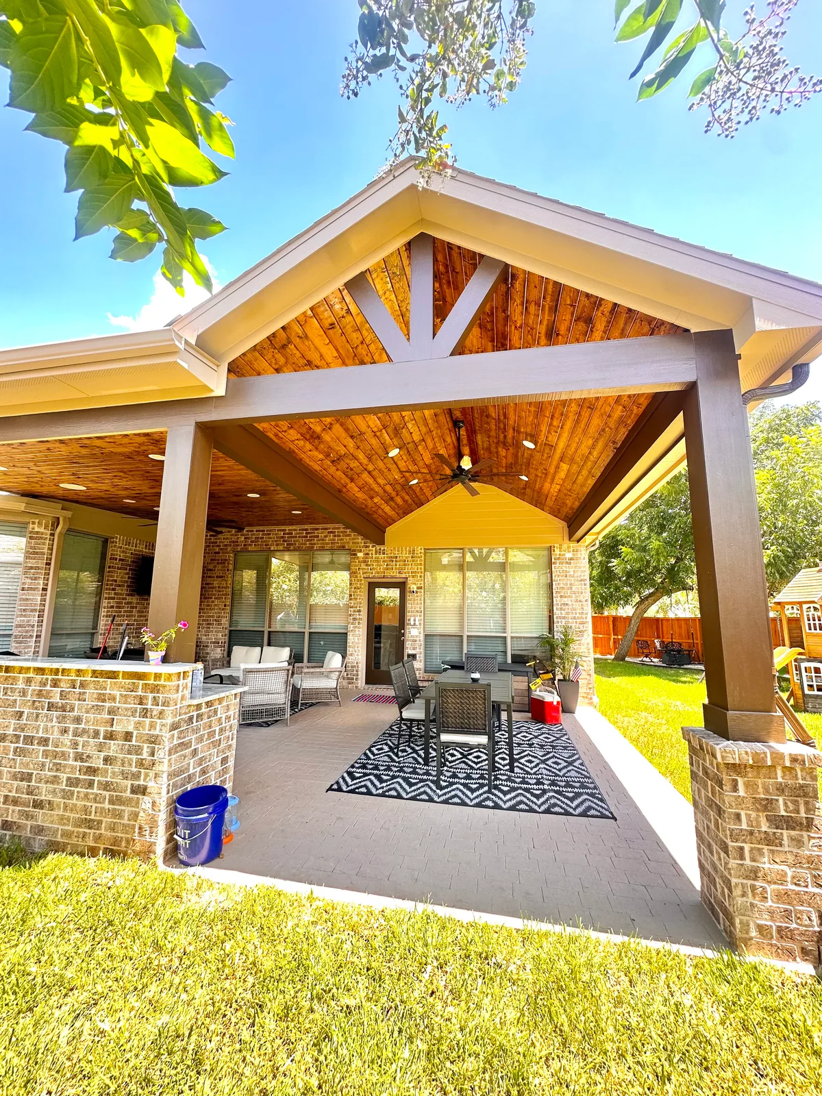 Custom patio cover with outdoor kitchen and stone columns in Houston TX