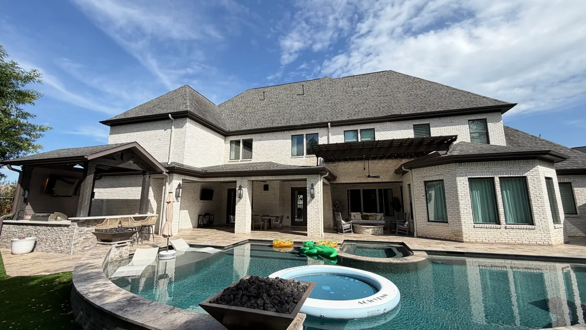 Luxury backyard patio cover with pool fire table and outdoor kitchen in Houston TX