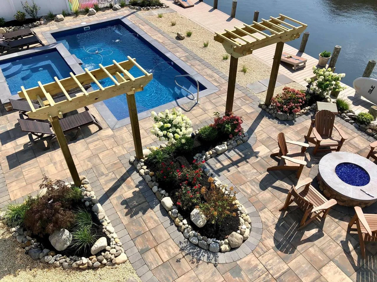 Aerial view of complete outdoor living space with pool, pergolas, paver patio and fire pit in Pearland TX