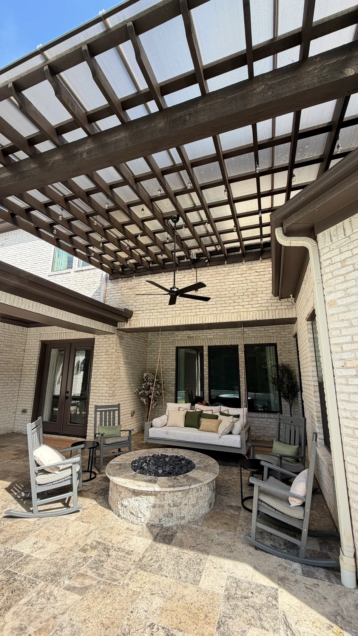 aerial view of louvered glass pergola pool and fire bowls at dusk in Houston TX