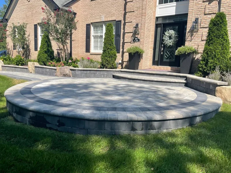Circular raised paver patio with custom stone seating wall in Rosenberg TX